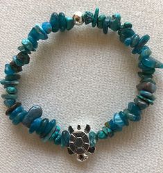 "Various African Turquoise stones with a silver centered turtle charm.  On a stretch bracelet string that helps putting on or off easily. This bracelet was strung by hand and can be made to order to fit your wrist perfectly. To measure your wrist, take a flexible tape measure around the base of your wrist and size it plus a 1/2 inch.  That way by adding a 1/2 of an inch, it will give your bracelet the ability to move on your wrist and it won't be so tight. I have another store with various items Adjustable Turquoise Crystal Bracelet With Gemstone Beads, Adjustable Turquoise Crystal Bracelet Hand-strung, Adjustable Turquoise Crystal Bracelet For Healing, Bohemian Adjustable Turquoise Charm Bracelet, Bohemian Turquoise Adjustable Charm Bracelet, Turquoise Stretch Bracelet With Natural Stones For Gift, Turquoise Stretch Bracelet With Gemstone Beads As Gift, Turquoise Stretch Bracelet With Natural Stones As Gift, Turquoise Gemstone Beads Stretch Bracelet As Gift