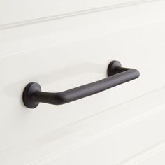 a black handle on a white cabinet door