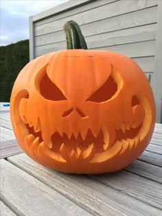 a carved pumpkin sitting on top of a wooden table