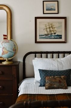 a bedroom with a bed, mirror and pictures on the wall above it is shown