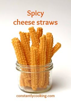 a jar filled with cheesy cheese straws on top of a white table