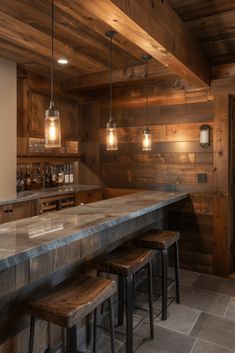 a bar with stools and lights hanging from the ceiling