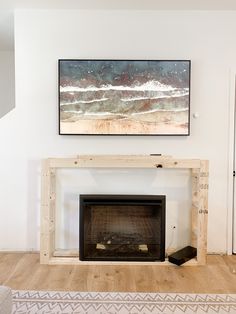 a living room with a fire place next to a painting on the wall above it