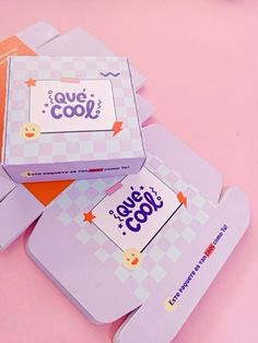 four boxes with stickers on them sitting next to each other in front of a pink background