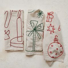 three hand embroidered christmas stockings hanging on a wall