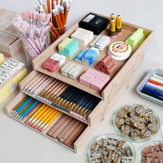 a wooden drawer filled with lots of different colored pencils