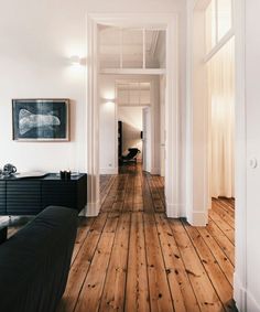 an empty room with wood floors and white walls