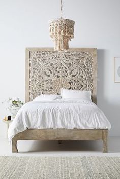 a bedroom with a bed, rug and chandelier hanging from the ceiling above it