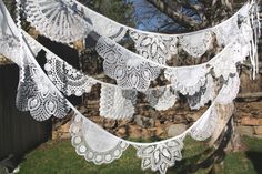 there are many white doily hanging from the tree