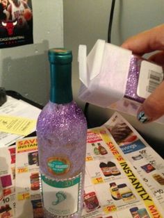 a person is opening up a purple bottle