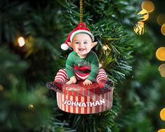 an ornament shaped like a baby's first christmas ornament hanging from a christmas tree