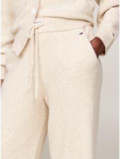 Tommy Hilfiger women's sleepwear. Nothing is better than lounging around in a pair of cozy, loose-fitting sweats—well, these were designed for just that. Made from a blend of nylon, acrylic and wool, woven in a jersey knit for a soft, subtle texture, our wide-leg lounge pant is made complete with an elastic drawstring waistband, pockets, and rib-knit hems.  Material: 47% Recycled Polyester, 33% Polyamide, 13% Acrylic. Cozy Winter Relaxation Bottoms, Cozy Winter Pants For Relaxation, Beige Sweatpants For Loungewear In Fall, Beige Sweatpants For Fall Loungewear, Beige Bottoms For Winter Loungewear, Casual Tommy Hilfiger Bottoms For Loungewear, Casual Tommy Hilfiger Loungewear Bottoms, Tommy Hilfiger Casual Loungewear Bottoms, Cozy Cream Sweatpants For Loungewear