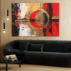 a living room with a black couch and painting on the wall