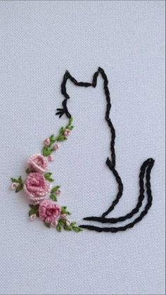 a cat with flowers on it's head is embroidered onto the back of a piece of fabric