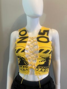 This cute and fun crop top features a stretchy material, black designs, and a front yellow tie-up closure. Material: 95% Polyester 5% Spandex Yellow Y2k Crop Top For Spring, Casual Crop Top With Graphic Print For Club, Trendy Graphic Print Crop Top For Club, Trendy Yellow Crop Top, Summer Club Crop Top With Graphic Print, Yellow Stretch Cropped Tank Top, Summer Graphic Print Crop Top For Club, Fitted Yellow Crop Top, Trendy Fitted Yellow Crop Top