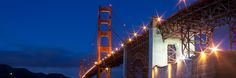 the golden gate bridge lit up at night with lights shining on it's sides