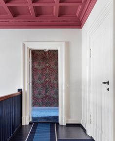 an empty hallway with blue and pink carpeting