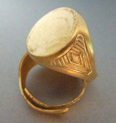 Solid thick raw brass ring, pretty matte gold color. Art deco design along the sides. Adjustable size, but on the bigger side. It wouldn't work for a small ring size. The back can be cut and soldered for permanent sizing. Probably best as a setting for a men's signet ring. 15 mm diameter top. One per listing. Engraved Brass Open Ring, Adjustable Gold Brass Signet Ring, Gold Rings With Antique Finish For Anniversary, Antique Finish Gold Rings For Anniversary, Antique Hand Cast Gold Rings, Gold Etched Brass Rings, Etched Yellow Gold Brass Ring, Ancient Gold Engraved Signet Ring, Gold Ancient Style Signet Ring For Ceremonial Use