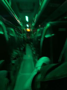 the inside of a bus with green lights on it's sides and seats down