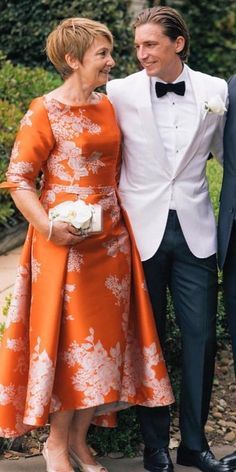 two people standing next to each other in formal wear