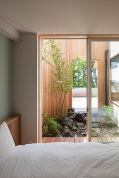 a bed sitting in a bedroom next to a sliding glass door that leads to a small garden