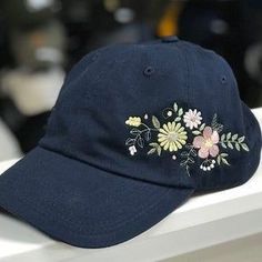 a baseball cap with embroidered flowers on it