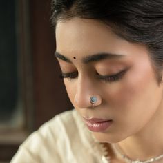 Inspired by the Firoza stone, a symbol of success, victory, and good fortune, this handcrafted nose pin is a delicate yet striking piece of jewelry. Featuring a radiant Firoza stone, the design is enhanced by an intricate Mughal art-inspired motif, offering a blend of traditional elegance and modern style. Made from silver-plated brass, this nose pin adds a touch of timeless beauty to any look, perfect for the festive season or everyday wear. Embrace the charm and prosperity of the Firoza Nose P Elegant Nose Studs For Gift, Spiritual Jewelry For Puja, Temple Jewelry Nose Ring With Tilla As Gift, Elegant Tilla Nose Rings As Gift, Silver Nose Rings As Gift, Temple Jewelry Style Nose Ring Gift, Handmade Nose Rings As Gift, Gift Temple Jewelry Nose Ring, Elegant Handmade Nose Rings For Gifts