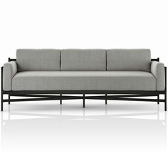 a gray couch sitting on top of a white floor next to a black metal frame