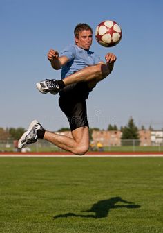 a man kicking a soccer ball in the air on a field royalty images and stock photos