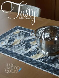 a metal bowl sitting on top of a wooden table next to a blue and white place mat