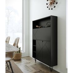 a black cabinet sitting on top of a hard wood floor next to a table and chairs