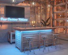 a bar with three stools in front of it and a television on the wall