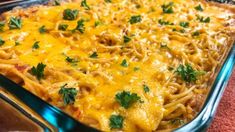 a casserole dish with noodles, cheese and parsley on top is shown