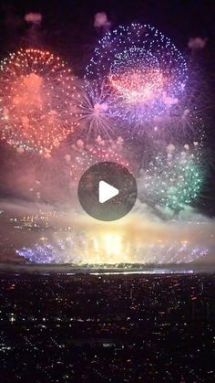 fireworks are lit up in the night sky above a cityscape with buildings and lights