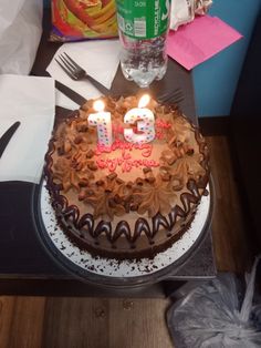 a birthday cake with lit candles sitting on a table