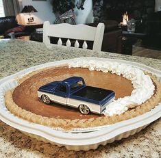 a blue pickup truck on top of a pie crust in the shape of a circle