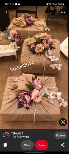 two boxes with flowers on them sitting on the floor next to each other, and one box is wrapped in brown paper