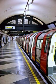 a subway train pulling into the station with its doors open