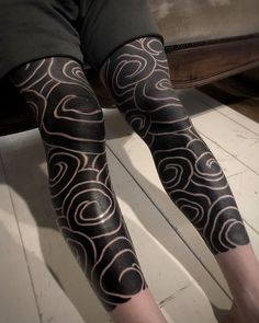 a person with black and white tattoos on their legs