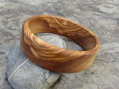 handmade Bracelet Bangle made out of fine olive wood Diameter inside 6,5 cm ( 2,56 inch) large 2 cm ( 0,79 inch) the olive wood is finely sanded and oiled with olive oil naturally the grain of the olive wood can vary from item to item , but in any case you will get a olive wood bracelet with beautiful grain This bangles are turned by us from a piece of olive wood. Handmade in Portugal In our Shop you can find more earrings , rings and necklaces made out of olive wood ! Bohemian Wood Bracelet Jewelry, Earthy Natural Wood Jewelry For Gifts, Natural Wood Bracelet Jewelry Gift, Handmade Wooden Bracelets As Gift, Handmade Wooden Bracelets Perfect As Gifts, Handmade Wooden Bracelets For Gifts, Handmade Natural Color Bangle Bracelets, Handmade Natural Color Bangle Bracelet, Natural Bangle Bracelets As Gift