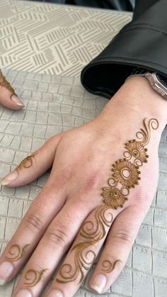 a woman's hand with henna tattoos on it