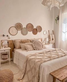 a white bedroom with wicker baskets above the bed