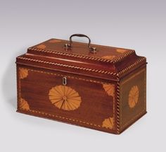 a wooden box with an intricate design on it's lid and handle, sitting on a white surface