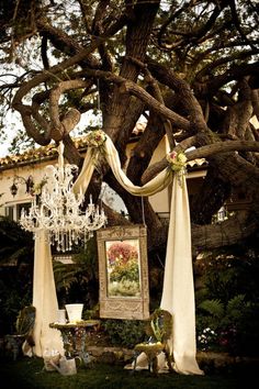 a chandelier hanging from a tree in front of a painting on the ground