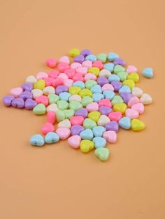 small candy hearts are scattered on an orange background