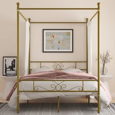 a bedroom with a four poster bed and pictures on the wall