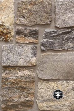 a stone wall that is made out of several different types of stones and has a black sticker on it