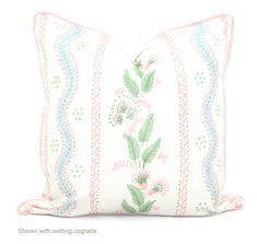 a white pillow with pink and blue trimmings on the front, sitting against a white background