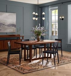 a dining room with blue walls and wooden floors