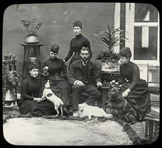 an old black and white photo of people with dogs